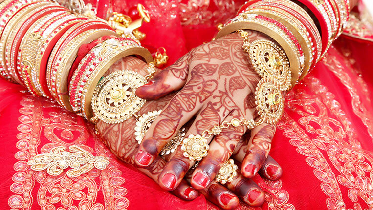 Close up of Decorative hands of Indian Bride with Golden Jewellery. Selective Focus is used